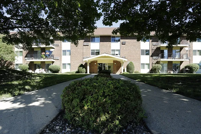 Charming apartment complex with lush landscaping and inviting balconies, perfect for enjoying outdoor relaxation.