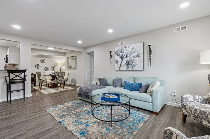 Contemporary open-plan living room with stylish decor, plush seating, and elegant dining area, highlighted by modern artwork and cozy ambiance.