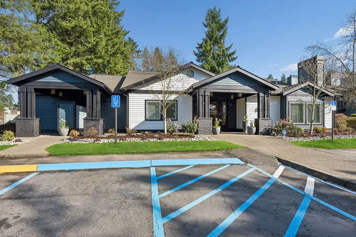 Charming apartment building with modern exterior, surrounded by lush greenery and a well-maintained pathway for welcoming ambiance.
