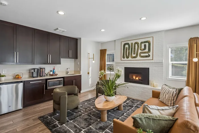 Modern open-concept living area with sleek kitchen, cozy fireplace, and elegant decor.
