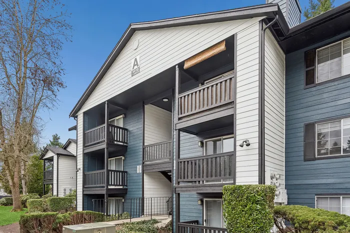 Charming apartment exterior with private balconies, modern design, and surrounded by lush greenery.