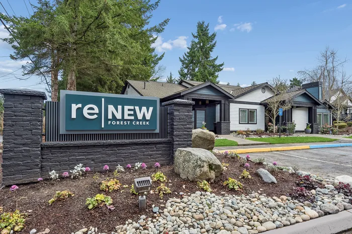 Charming exterior view of the Renew Forest Creek community, featuring manicured landscaping and modern architecture surrounded by lush greenery.