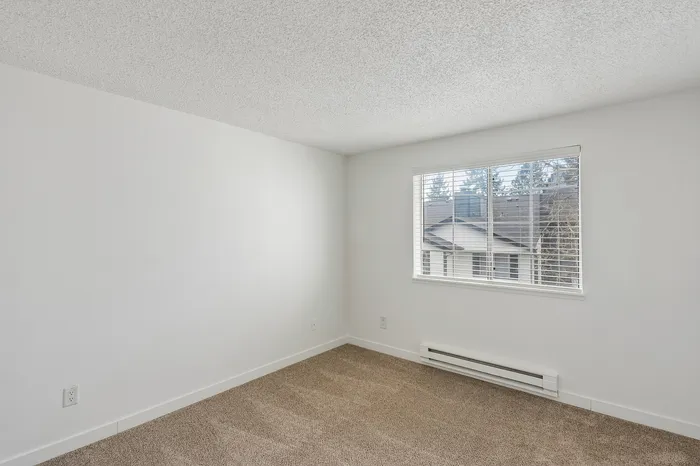Bright and airy bedroom with new carpet and large window offering scenic views.