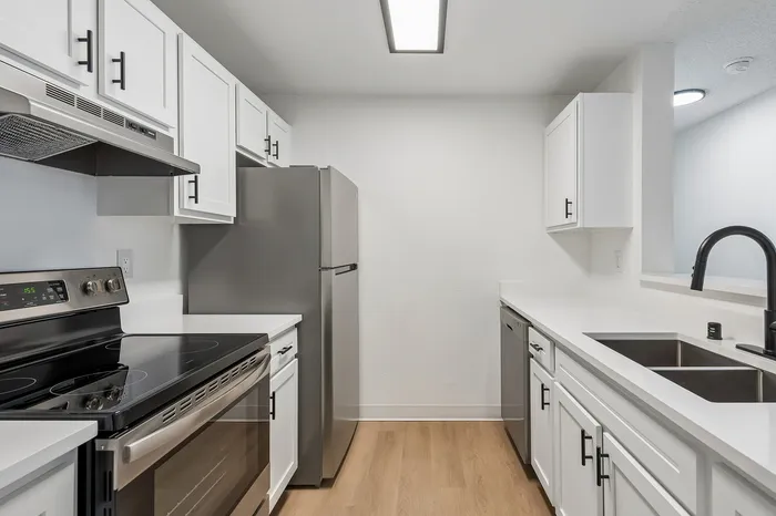 Sleek modern kitchen with stainless steel appliances, white cabinetry, and elegant countertops, perfect for culinary enthusiasts.