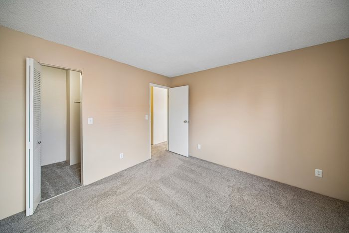 Bright and airy bedroom with neutral walls, plush carpet, and ample closet space, perfect for creating your personal sanctuary.