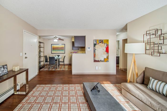 Modern and inviting living space showcasing open-concept design with cozy dining area, stylish artwork, and sleek furnishings.