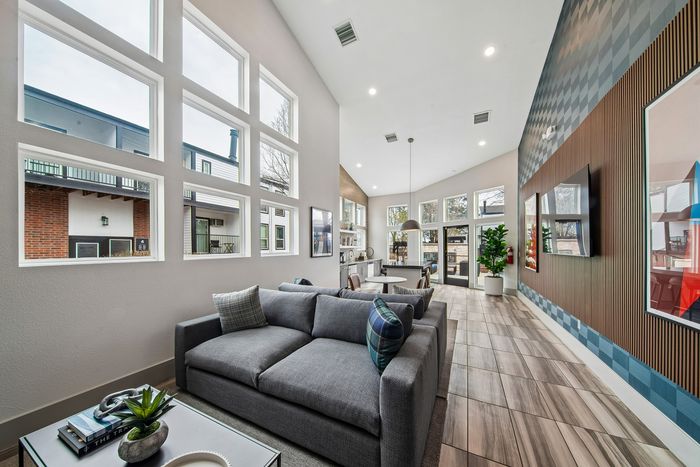 Modern living room with high ceilings, large windows, and stylish decor complementing a spacious open-concept layout.