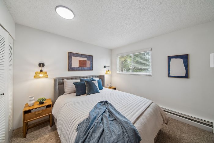 Inviting bedroom with plush bed, elegant decor, and natural light from a large window.