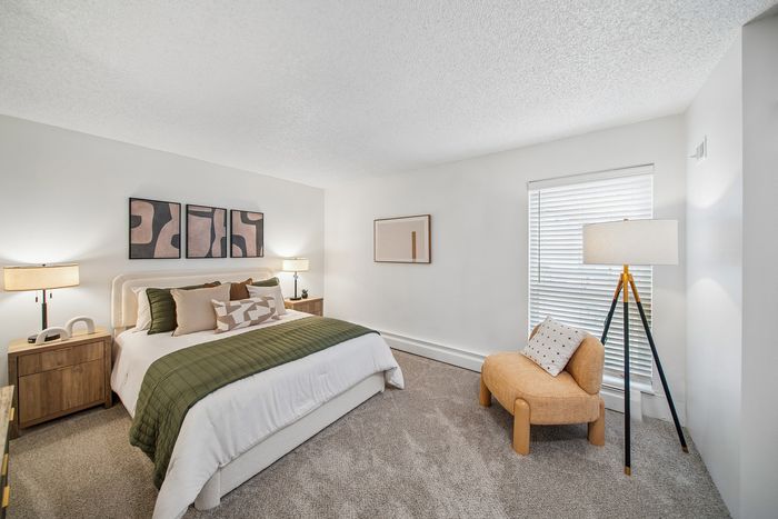 Elegant bedroom with modern decor, featuring a cozy bed with stylish pillows, ambient lighting, and tasteful artwork, offering a serene retreat.