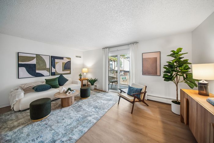 Bright, modern living room with stylish decor, cozy seating, and a view of the outdoor patio.