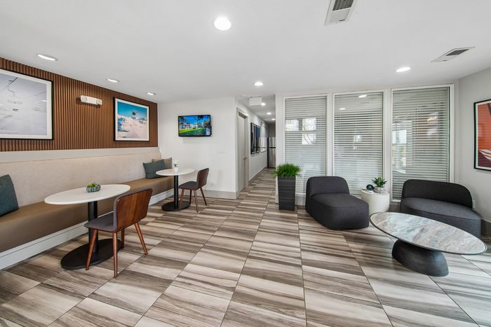 Modern communal area with chic seating, elegant round tables, and vibrant wall art, perfect for social gatherings and relaxation.