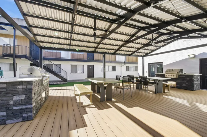 Inviting outdoor patio area with modern pergola, stylish dining set, and built-in BBQ grill, ideal for entertaining and relaxation.