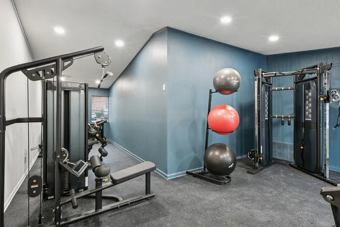 Modern apartment gym with state-of-the-art equipment and vibrant walls, perfect for fitness enthusiasts.