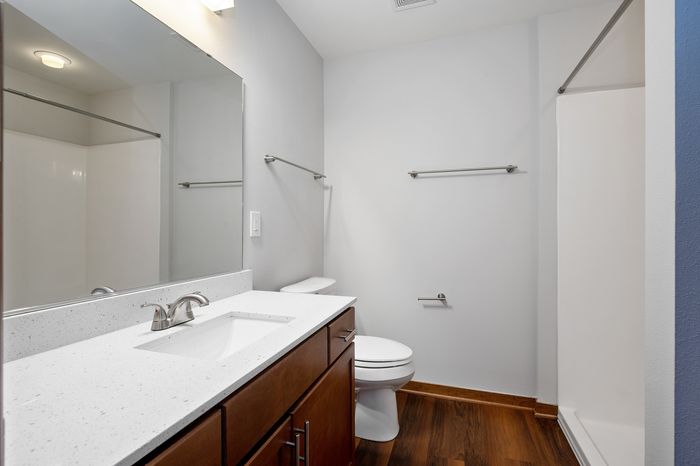 Elegant bathroom with sleek fixtures, wooden cabinetry, and a spacious vanity, offering a serene and modern design.