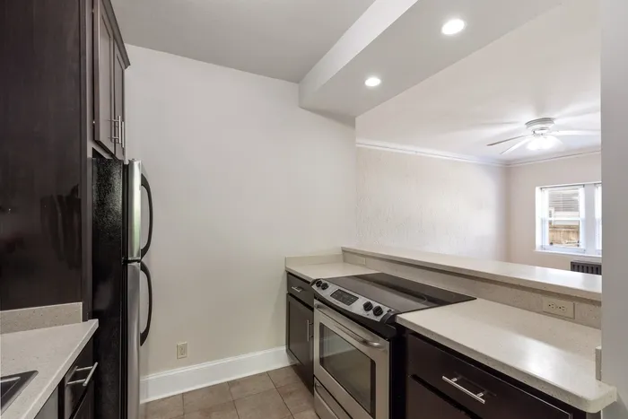 Contemporary kitchen with sleek dark cabinetry, modern appliances, and an inviting open layout with breakfast bar.