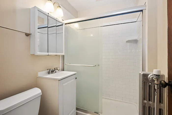 Chic and modern bathroom with sleek glass shower, elegant vanity, and bright lighting, offering a refreshing ambiance.
