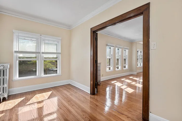 Bright and inviting living area with gleaming hardwood floors and abundant natural light from large windows.