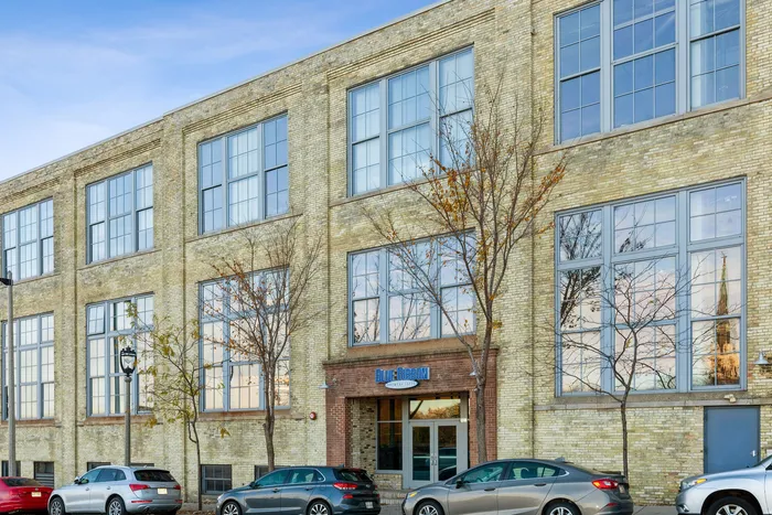 Elegant urban apartment building with large windows and charming brick facade, perfect for city living.