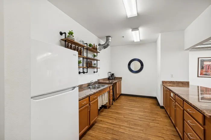 Contemporary kitchen with sleek granite countertops, elegant wood cabinetry, and stylish open shelving, creating a sophisticated and modern atmosphere.