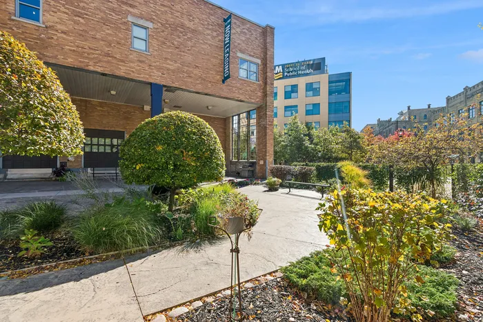 Charming outdoor entrance with lush landscaping and modern brick facade, offering a welcoming and vibrant living space.