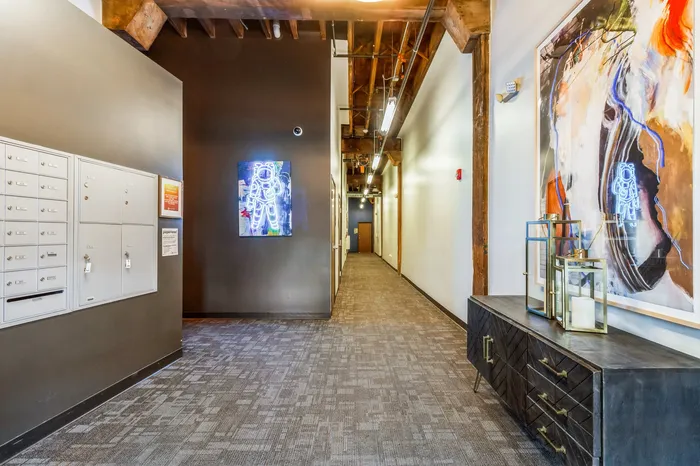 Chic apartment hallway with modern art, ambient lighting, and stylish decor, emanating urban elegance.