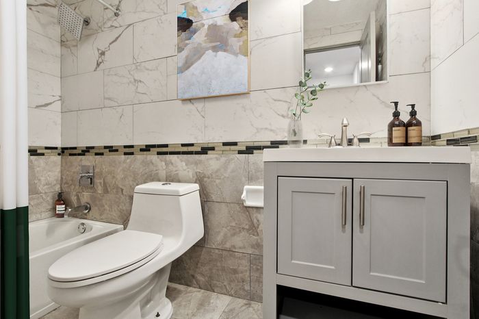 Elegant bathroom with modern sink, stylish cabinetry, and luxurious marble tile decor.