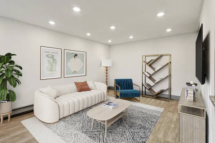 Modern living room with elegant decor, plush white sofa, stylish blue velvet chair, and geometric bookshelf, offering a cozy and sophisticated ambiance.