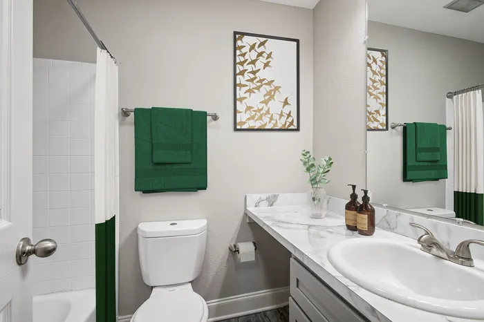 Elegant bathroom with a marble countertop, stylish decor, and vibrant green accents creating a fresh, modern atmosphere.