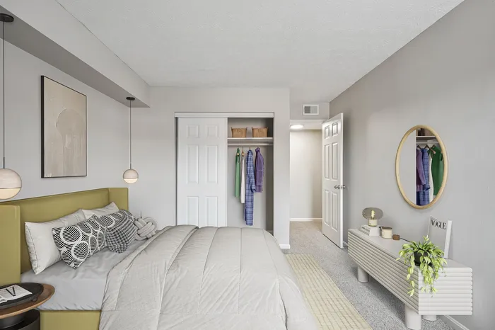 Elegant bedroom featuring modern decor, plush bedding, and a convenient open closet with hanging clothes.