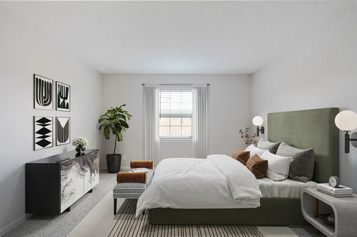 Bright and modern bedroom with stylish decor, featuring a plush green headboard, patterned artwork, and abundant natural light.