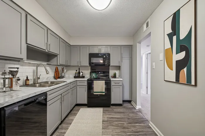 Contemporary kitchen with sleek grey cabinetry, modern appliances, and elegant marble countertops.