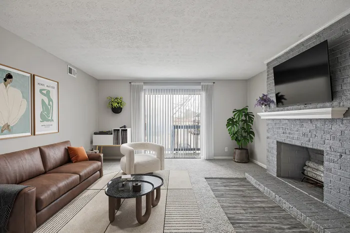Modern living room with stylish brown leather couch, artistic wall decor, sleek fireplace, and large window with natural light.