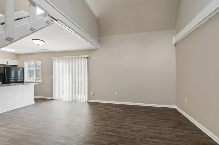 Spacious and modern apartment interior featuring an open-concept kitchen and living area with elegant hardwood floors and ample natural lighting.