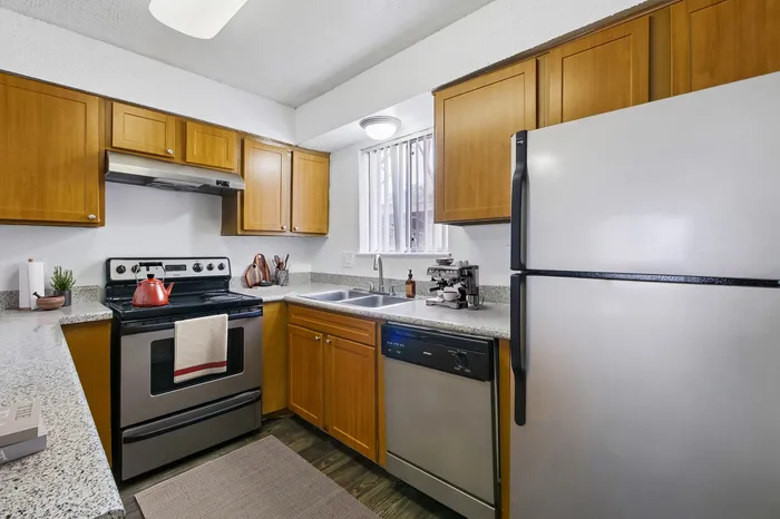 Modern kitchen with wooden cabinetry, sleek stainless steel appliances, and elegant granite countertops.