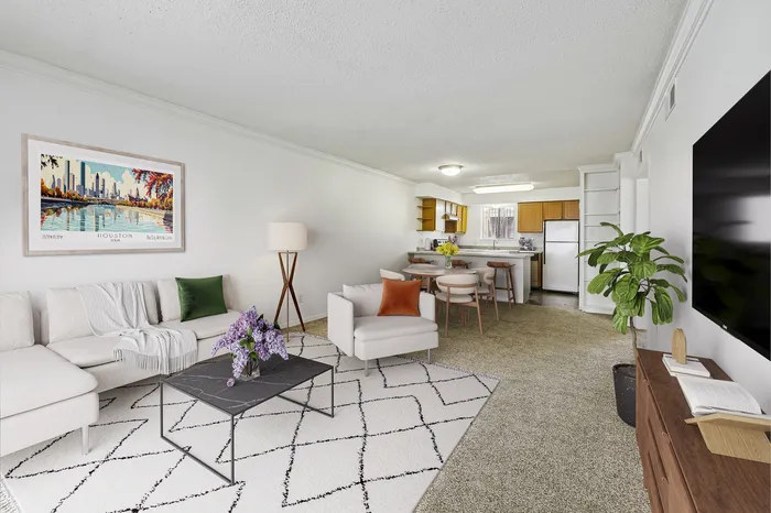 Elegant open-concept living room and kitchen featuring contemporary furniture, lush green plant, stylish artwork, and modern appliances.