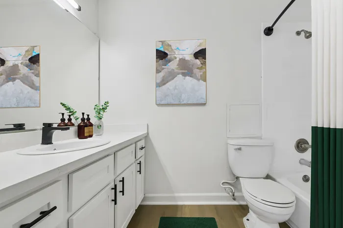 Modern bathroom featuring sleek cabinetry, contemporary fixtures, and elegant wall art for a stylish touch.