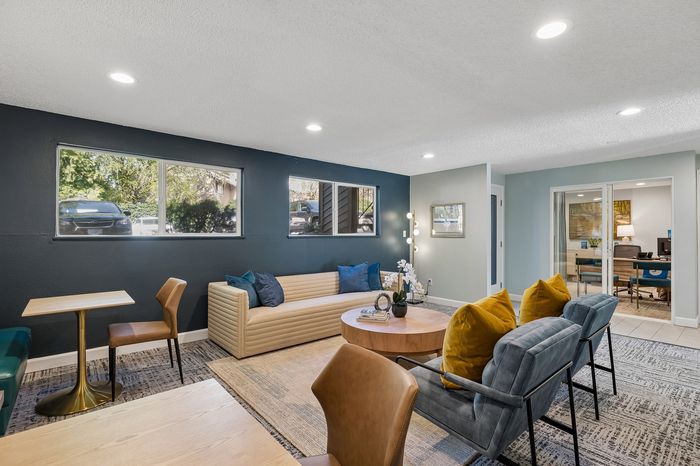 Inviting modern lounge with plush seating, vibrant decor, and natural light creating a warm, welcoming atmosphere.
