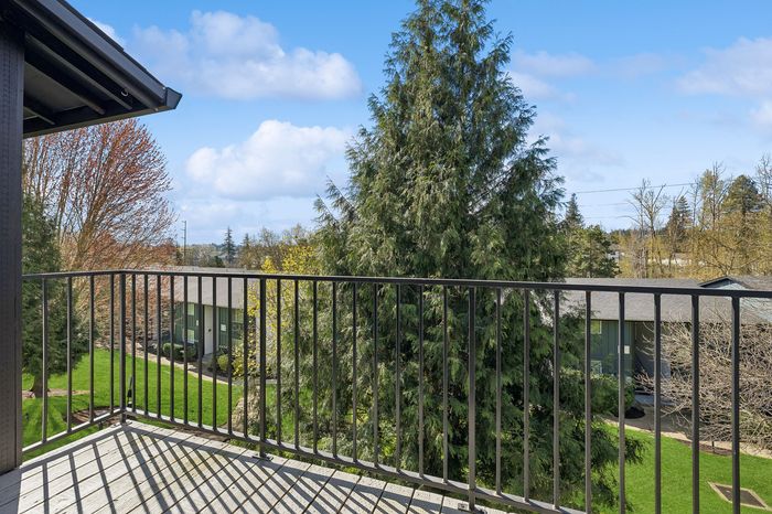 Serene balcony view overlooking lush greenery and vibrant trees, perfect for relaxation and enjoying nature.