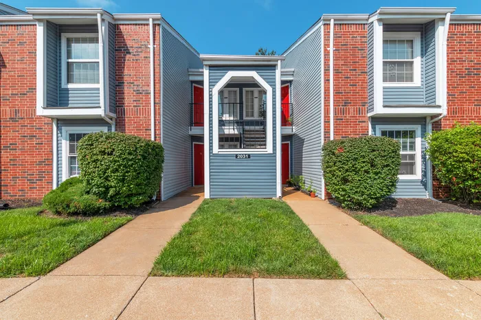 Charming red-brick apartment building with welcoming entryway and well-maintained landscaping.