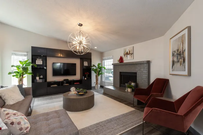 Chic living room with stylish decor, featuring modern lighting, cozy seating, and a sleek entertainment center.