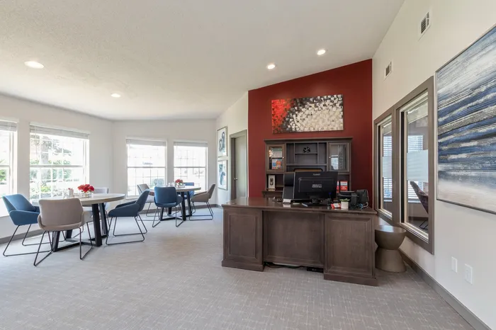 Bright and modern leasing office featuring stylish seating areas and expansive windows, perfect for welcoming guests.