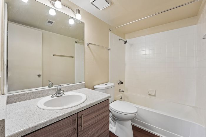 Bright and modern bathroom with sleek fixtures, large vanity mirror, and a spacious bathtub for comfort and relaxation.