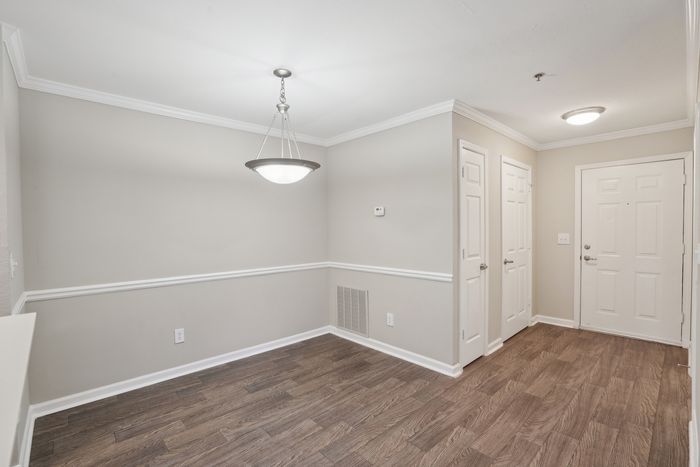 Charming apartment entryway featuring elegant hardwood floors and modern lighting, offering a welcoming ambiance.