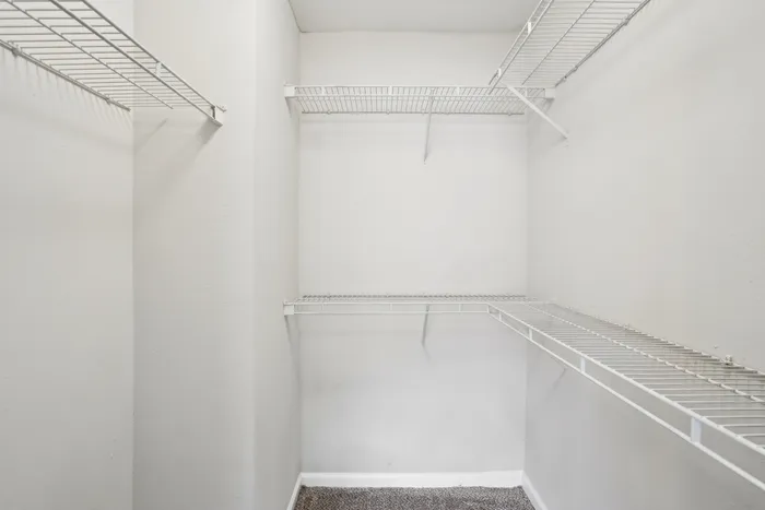 Spacious walk-in closet with wire shelving, perfect for organized storage and easy access.