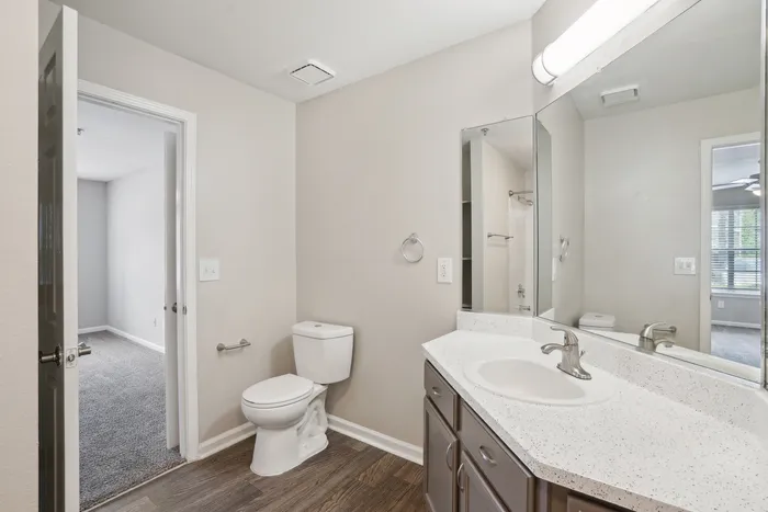 Bright and modern bathroom with sleek fixtures, elegant sink area, and cozy adjacent room, featuring a stylish, minimalist design.