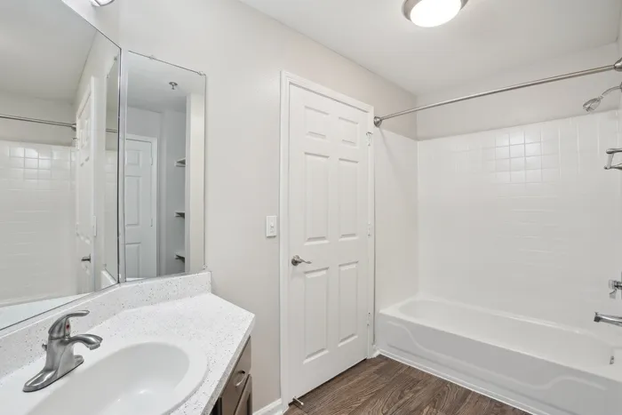 Modern bathroom with elegant white tiles, sleek fixtures, and stylish vanity, offering a serene retreat.