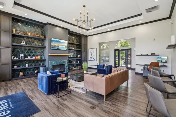 Elegant apartment lounge with modern decor, featuring plush seating, a stylish fireplace, and a sophisticated library wall.