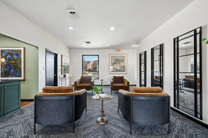 Elegant modern lounge area with stylish seating, vibrant art pieces, and large windows offering natural light.