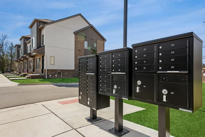Modern townhouse row with sleek black mailboxes in a vibrant neighborhood, offering convenient and stylish living.