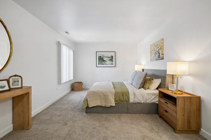 Inviting bedroom with plush carpeting, stylish decor, and a cozy bed, perfect for a restful retreat.